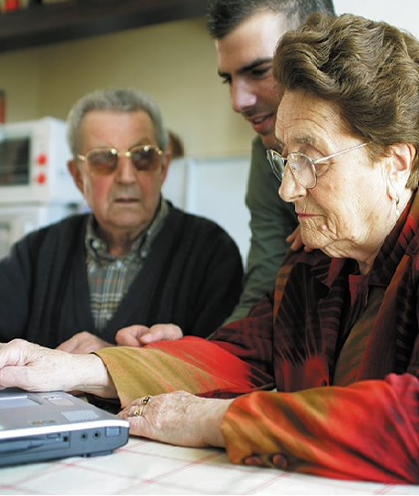 Jonge man met ouder echtpaar met pc